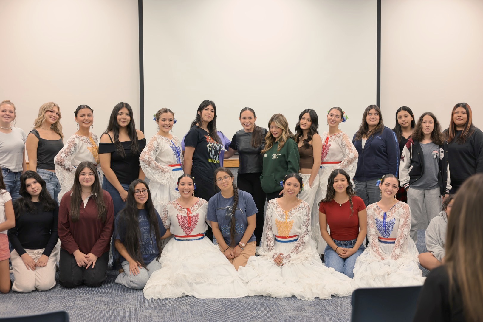 Ella Rises teens and guest performers smiling together after a cultural dance workshop