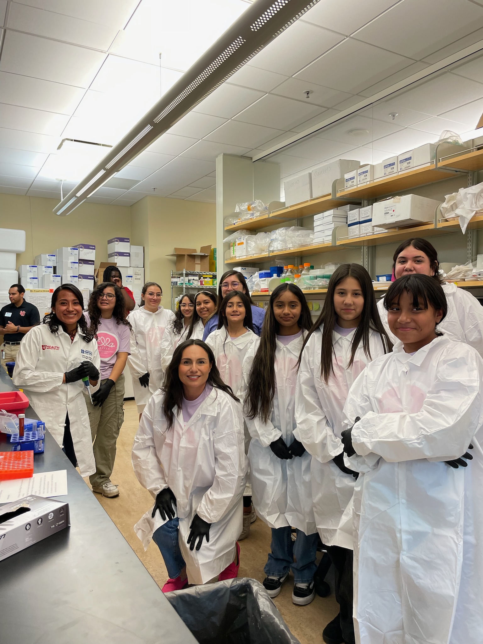 Ella Rises students wearing lab coats and gloves in a biomedical research lab